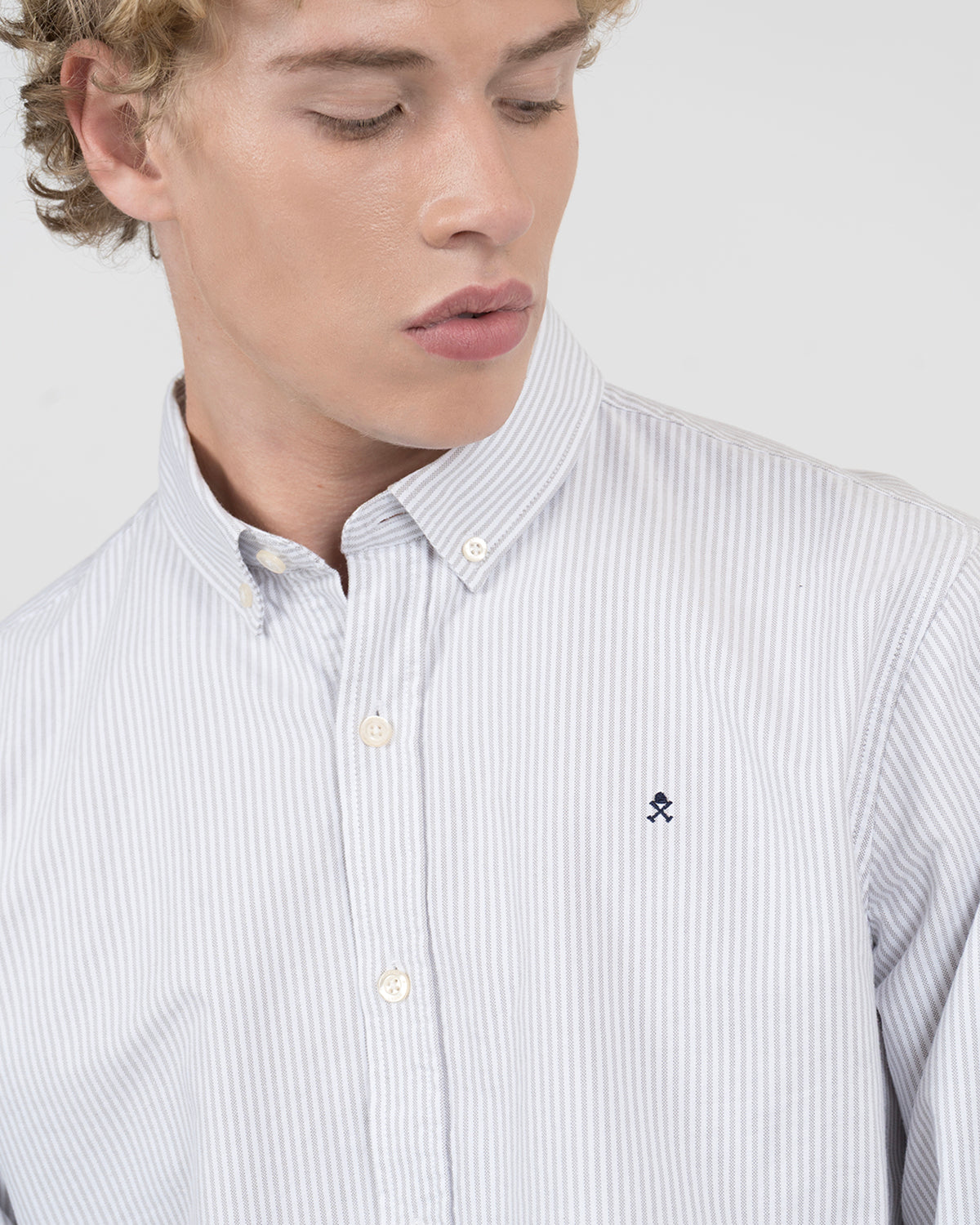 Detalle macro del cuello button down y logo bordado de la camisa MEDITERRANEO a rayas grises Harper & Neyer