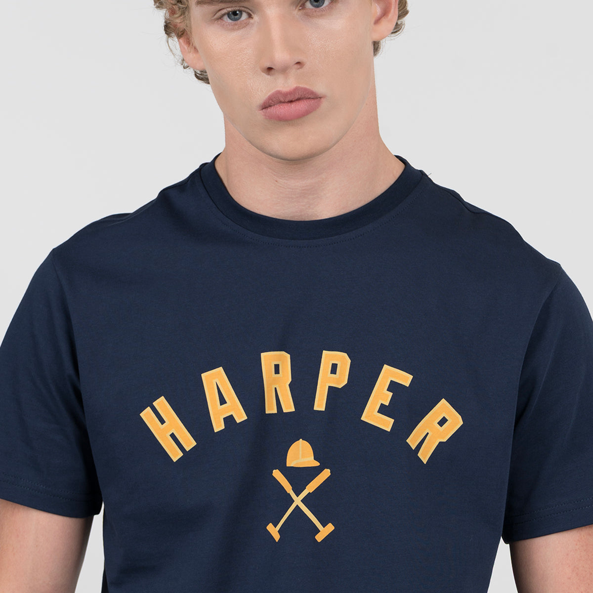 Detalle del gráfico HARPER amarillo con casco y mazos de polo en la camiseta NEW ENGLAND azul marino de Harper & Neyer