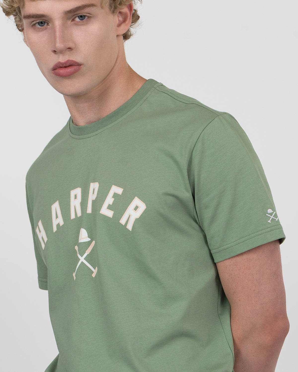 Detalle del gráfico HARPER con casco y mazos de polo en la camiseta NEW ENGLAND verde salvia de Harper & Neyer