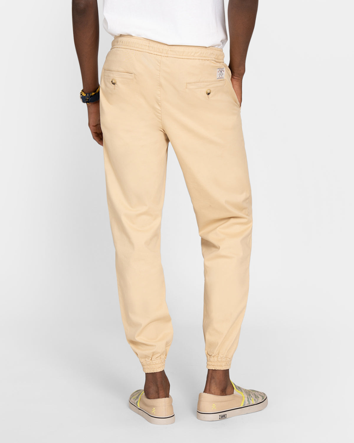 Vista trasera del Pantalón Jogger Twill en camel con modelo, bolsillos traseros y parche Harper 1985 Jogger visible