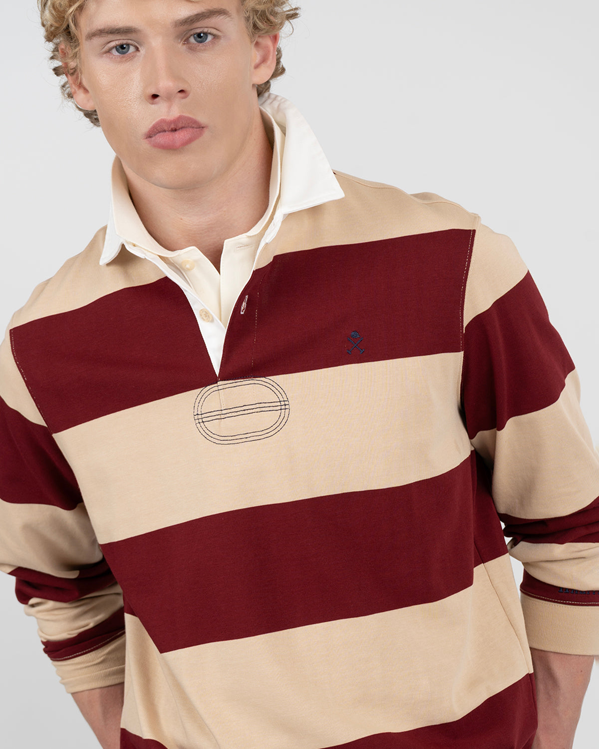 Detalle del cuello crudo y tapeta de tres botones del polo RUGBY burdeos y beige arena de Harper & Neyer