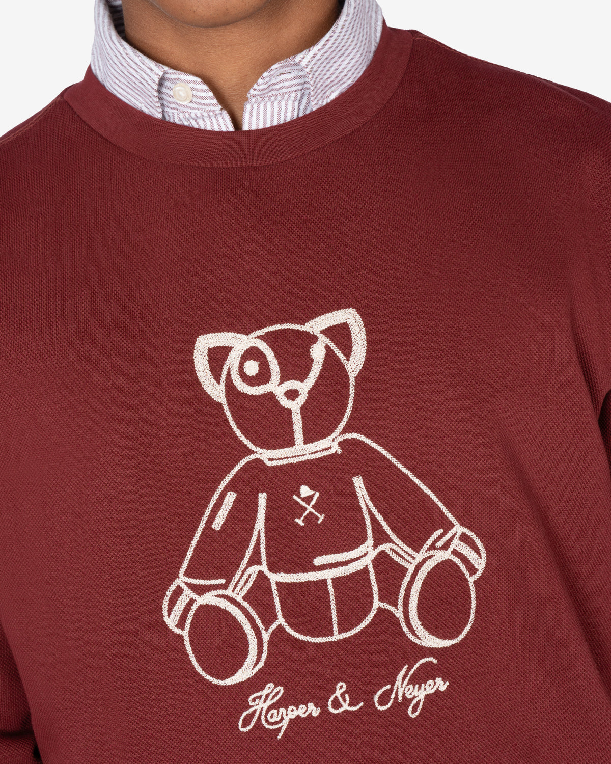 Detalle del oso ilustrado bordado a línea en hilo crudo con firma Harper & Neyer de la sudadera FLUFFY BEAR burdeos