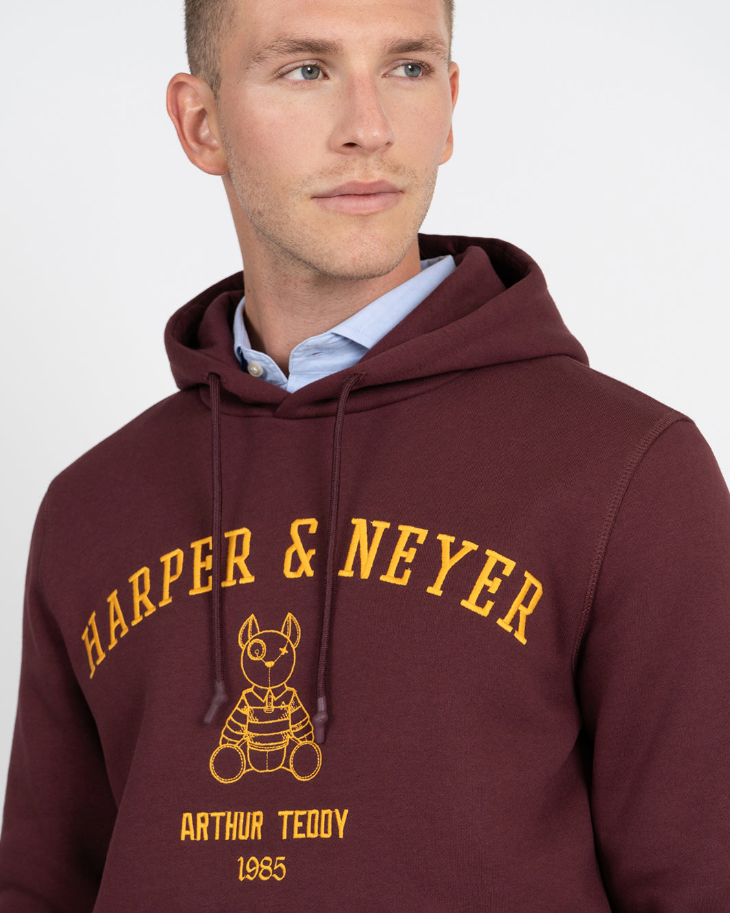Sudadera Hoodie Arthur de Harper & Neyer en burdeos, detalle del lettering dorado y mascota bordada