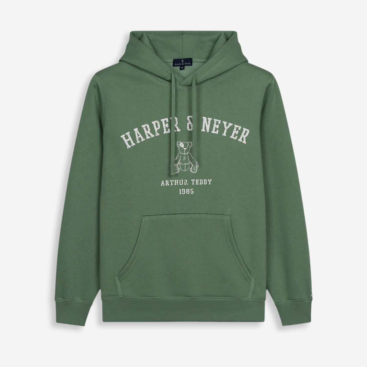 Sudadera MANCHESTER de Harper & Neyer en verde salvia, vista frontal con capucha, estampado Harper Neyer arqueado y oso Arthur Teddy bordado