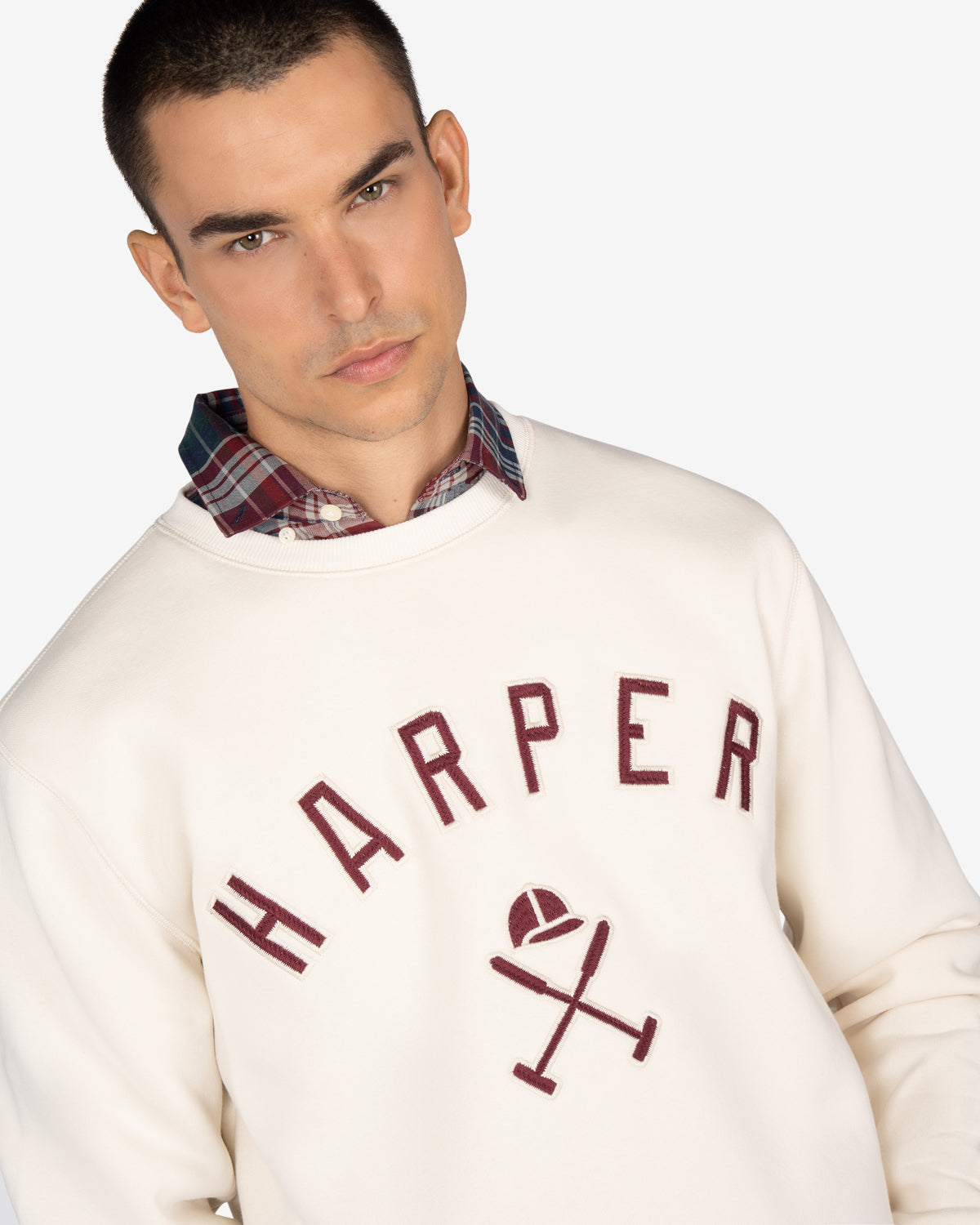 Sudadera NEW ENGLAND de Harper & Neyer en crudo, plano medio con HARPER varsity y camisa a cuadros asomando