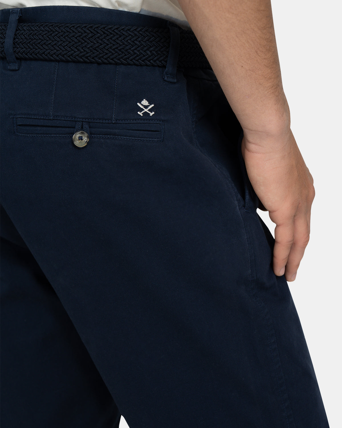 Detalle del bolsillo trasero de la Bermuda Icon Chino con bordado logo de la marca en blanco y cinturón trenzado azul