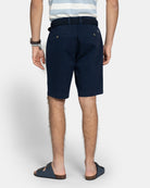 Vista trasera de la Bermuda Icon Chino en azul marino con modelo, bolsillos traseros con botones