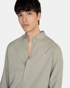 Detalle del cuello button-down y bordado logo de la marca en pecho de la camisa Royal Academy en verde gris