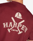 Detalle del estampado varsity Harper con casco de polo en la camiseta MICHIGAN de Harper & Neyer en burdeos