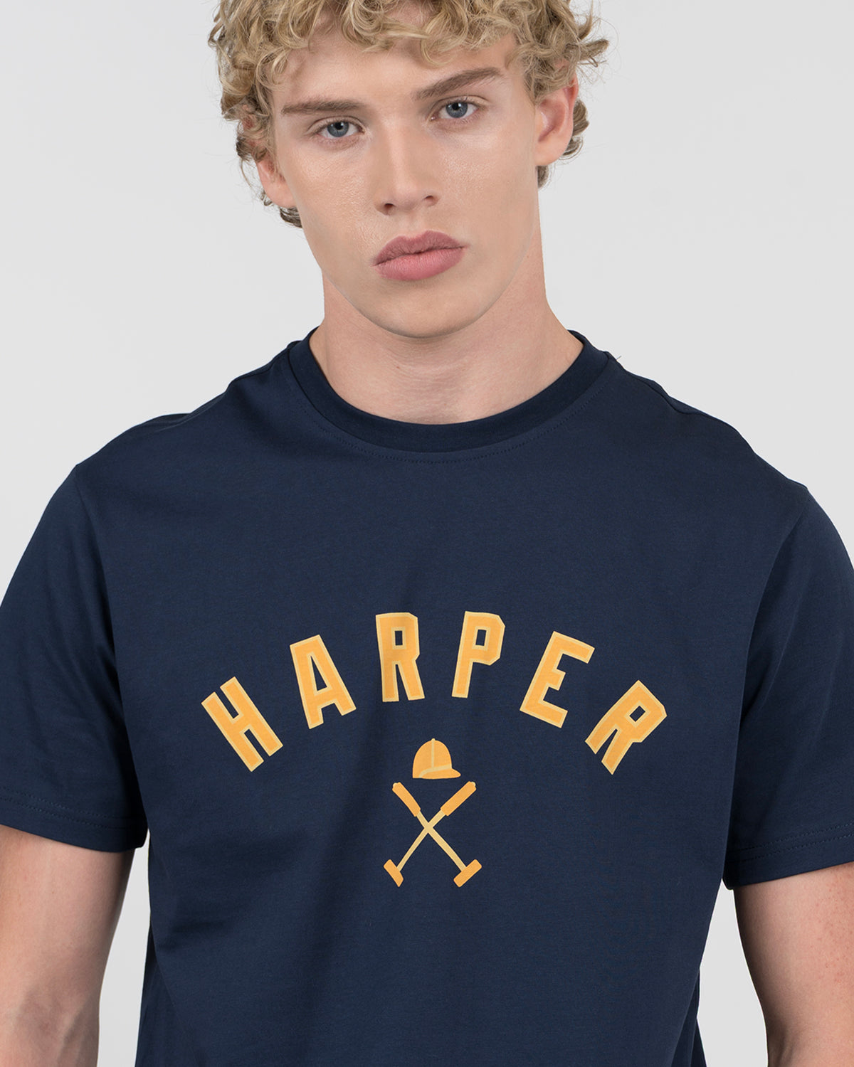 Detalle del gráfico HARPER amarillo con casco y mazos de polo en la camiseta NEW ENGLAND azul marino de Harper & Neyer