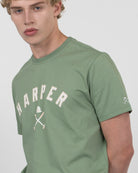 Detalle del gráfico HARPER con casco y mazos de polo en la camiseta NEW ENGLAND verde salvia de Harper & Neyer