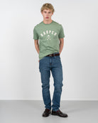Camiseta NEW ENGLAND de Harper & Neyer en verde salvia, vista frontal completa con vaquero y mocasines