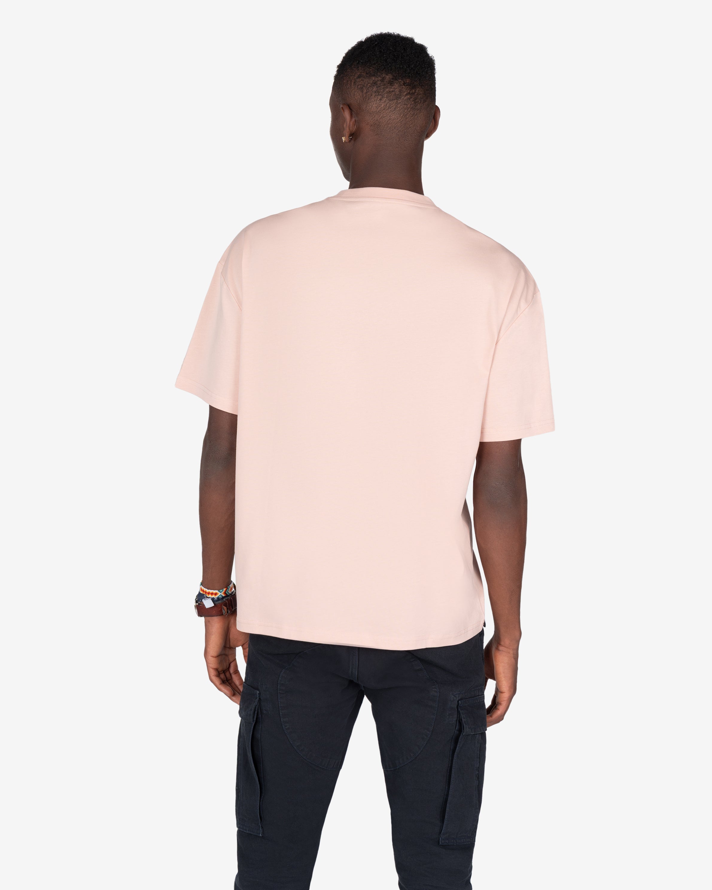 Camiseta NEWPORT oversize rosa empolvado de Harper & Neyer, vista trasera con modelo y pantalón cargo negro