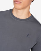 Detalle del logo bordado en azul marino sobre antracita de la camiseta PARADISE de Harper & Neyer