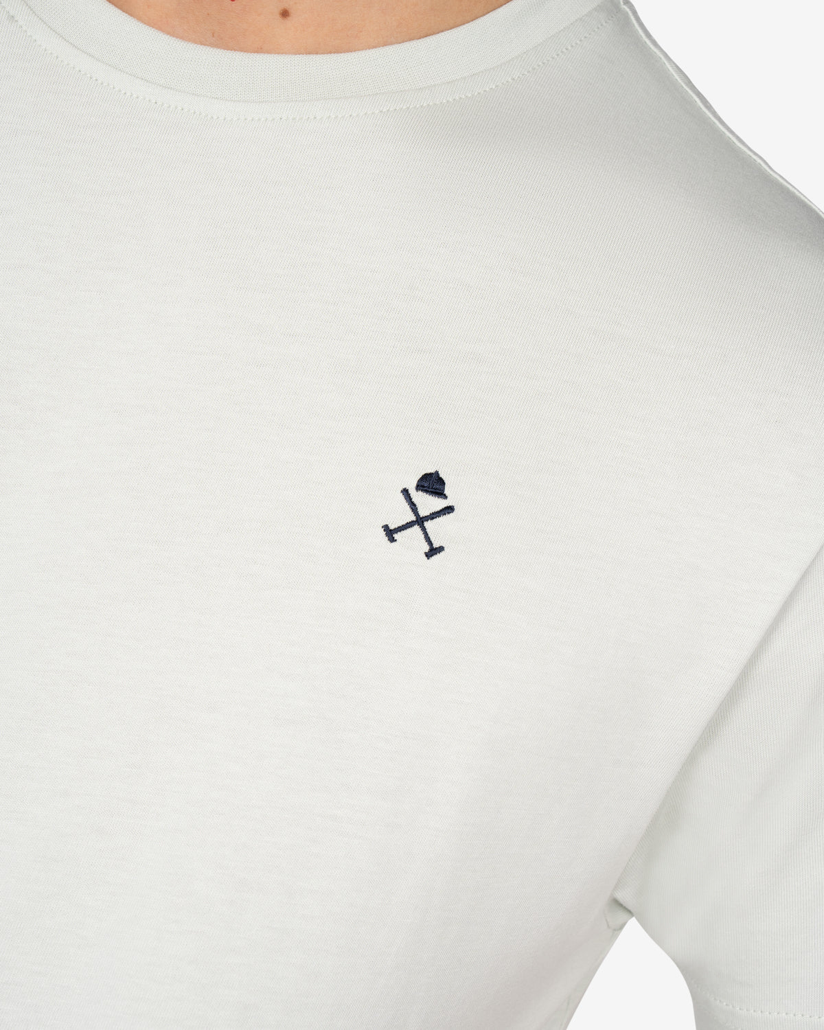 Detalle del logo bordado en azul marino de la camiseta PARADISE gris perla de Harper & Neyer