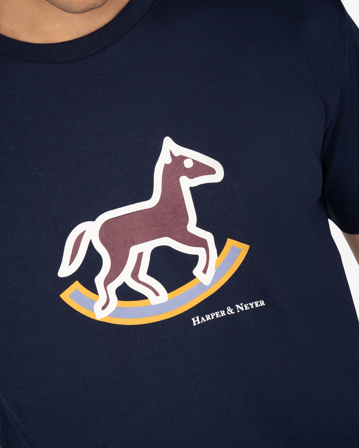 Detalle del caballo de balancín estampado en la camiseta ROCKING HORSE de Harper & Neyer en azul marino