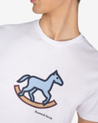 Detalle del caballo de balancín estampado en la camiseta ROCKING HORSE de Harper & Neyer en blanco