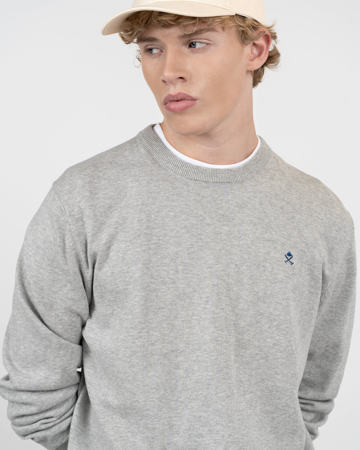 Detalle del cuello redondo y bordado del jersey ICON gris jaspeado de Harper & Neyer con casco y mazos de polo