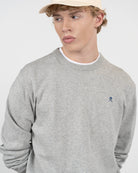 Detalle del cuello redondo y bordado del jersey ICON gris jaspeado de Harper & Neyer con casco y mazos de polo