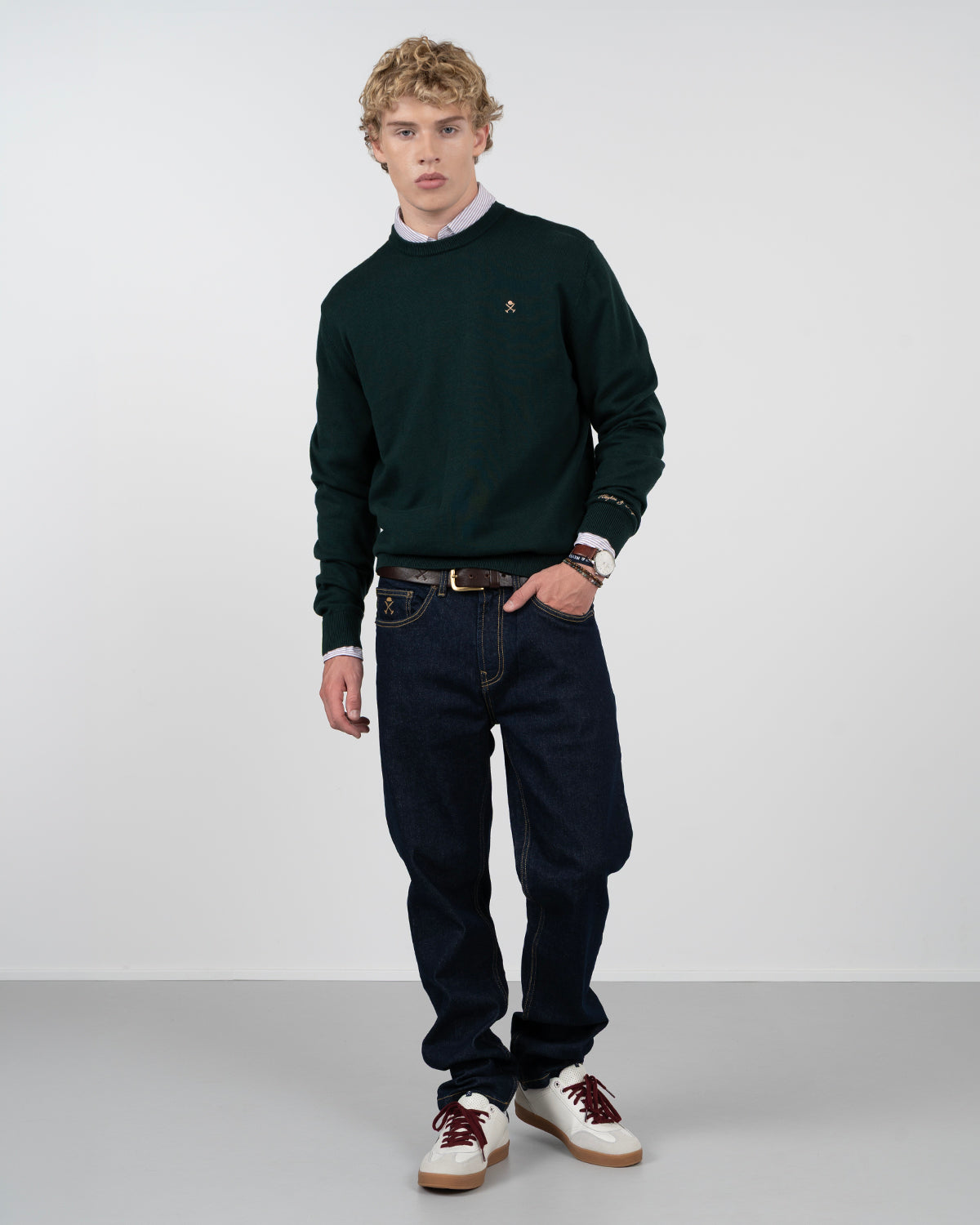 Jersey ICON de Harper & Neyer en verde botella, vista frontal completa con vaquero oscuro y sneakers
