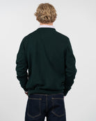 Jersey ICON en algodón verde botella de Harper & Neyer, vista trasera con camisa de rayas asomando en el cuello
