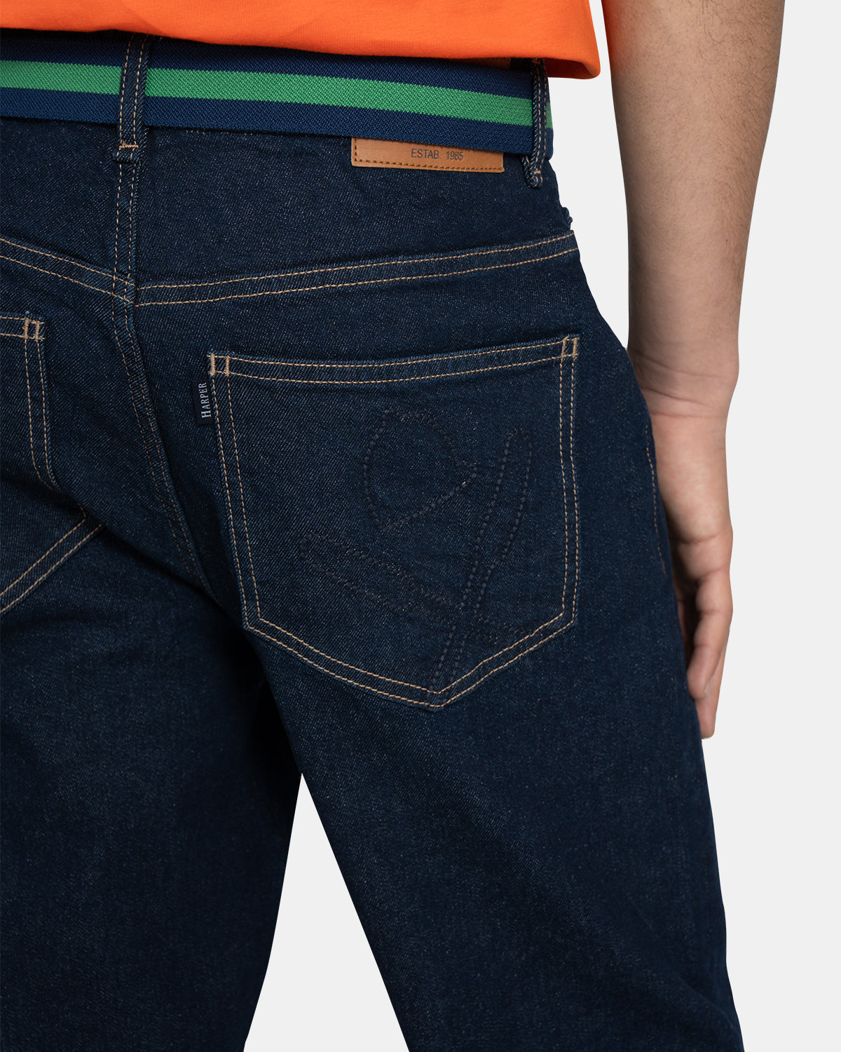 Detalle del bolsillo trasero del Pantalón Denim con logo bordado tonal, parche de cuero Estab. 1985 y cinturón bicolor