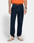 Pantalón Denim en azul oscuro, plano medio frontal con logo de la marca en bolsillo y costuras en contraste marrón