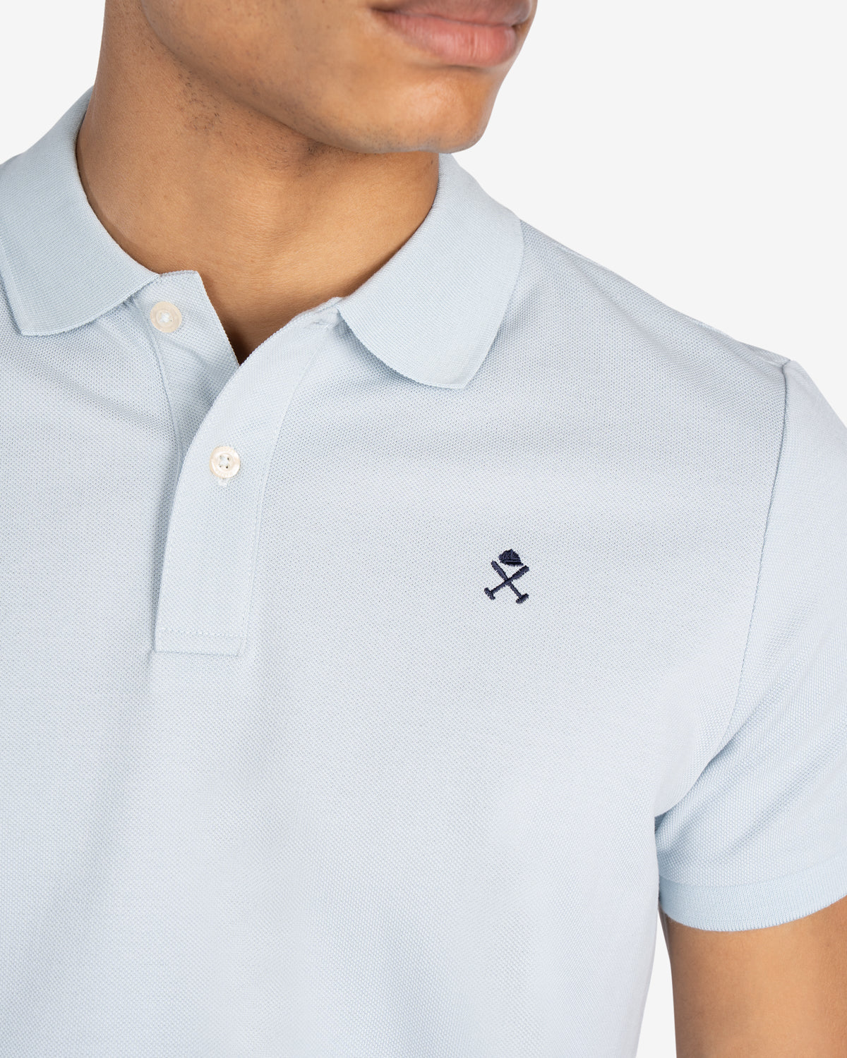 Detalle del cuello, tapeta de botones y logo bordado en azul marino del polo ICON COLORS azul cielo de Harper & Neyer