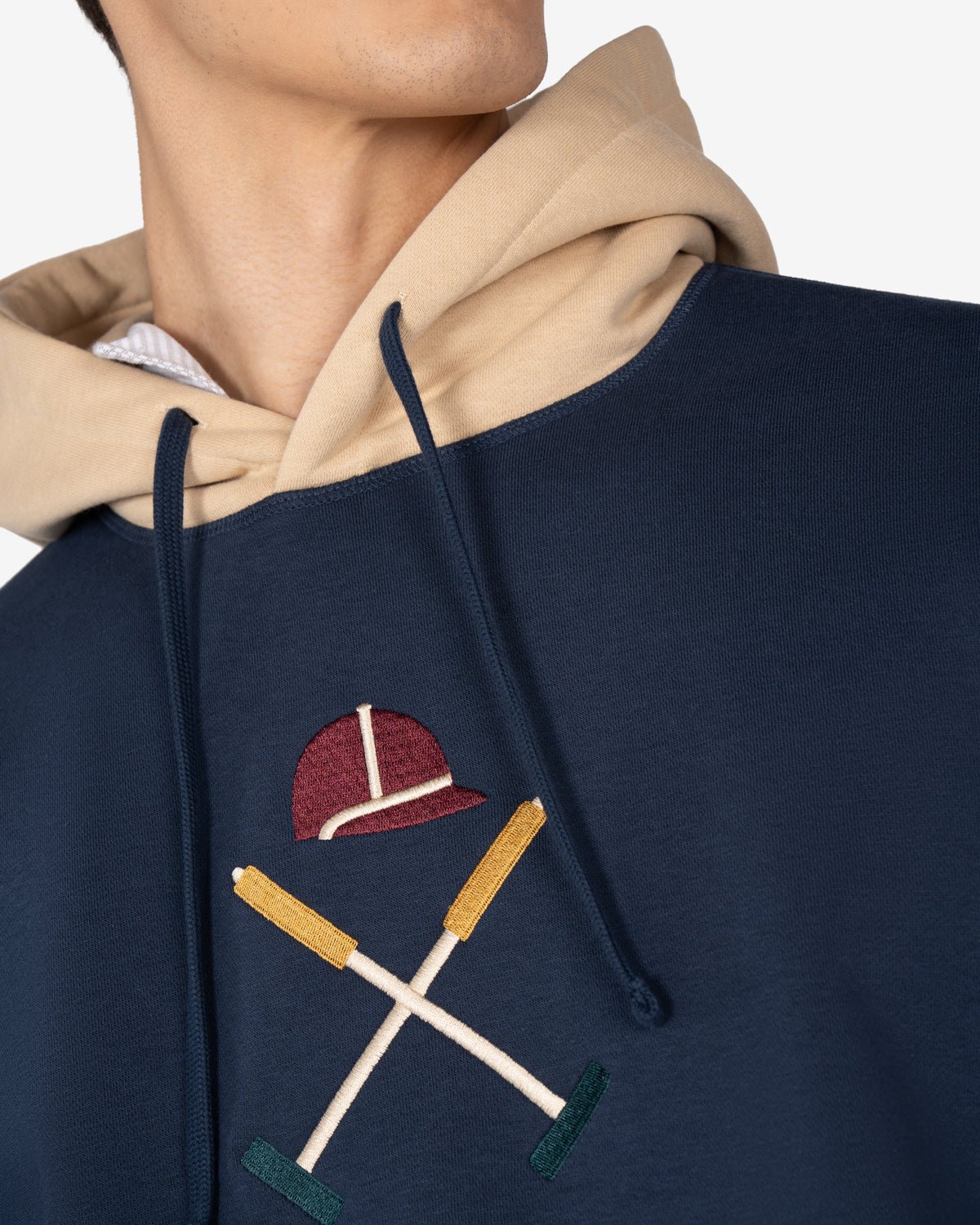 Detalle del bordado grande casco y mazos con rima cromática en burdeos, mostaza y verde de la sudadera ATLANTHA multicolor
