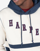 Detalle del bordado HARPER en appliqué azul marino con contorno rojo y costuras zig zag contrastadas de la sudadera DALLAS