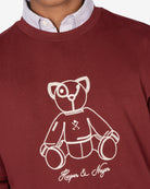 Detalle del oso ilustrado bordado a línea en hilo crudo con firma Harper & Neyer de la sudadera FLUFFY BEAR burdeos