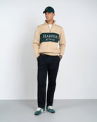 Sudadera Half-Zip Maryland de Harper & Neyer en camel, detalle del panel verde y tipografía serif crudo