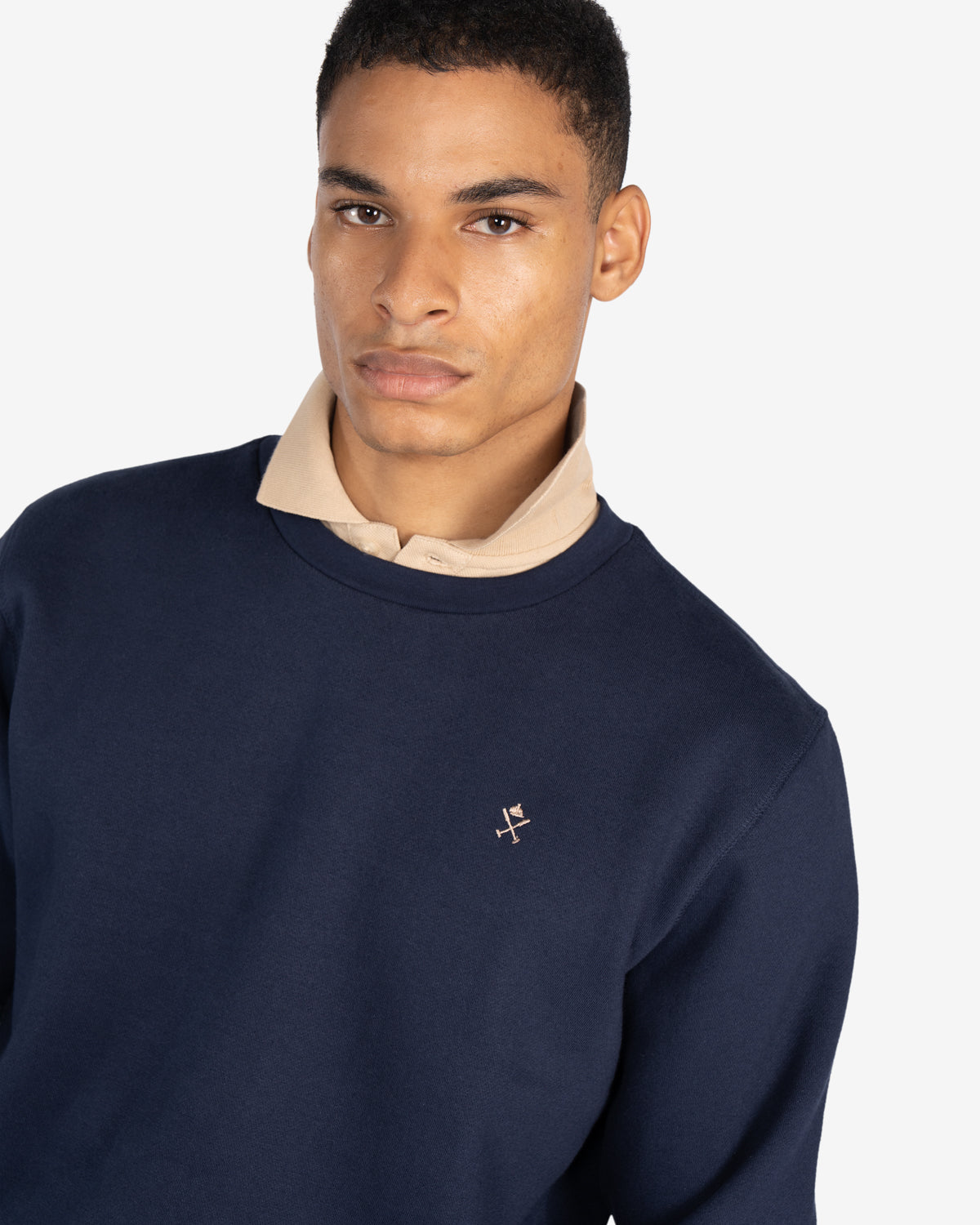 Sudadera ICON de Harper & Neyer en azul marino, plano medio con polo beige asomando por el cuello
