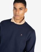 Sudadera ICON de Harper & Neyer en azul marino, plano medio con polo beige asomando por el cuello