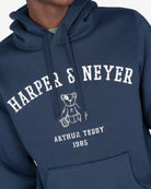 Detalle del estampado Harper Neyer arqueado en efecto vintage y osito Arthur Teddy bordado en la sudadera MANCHESTER azul marino