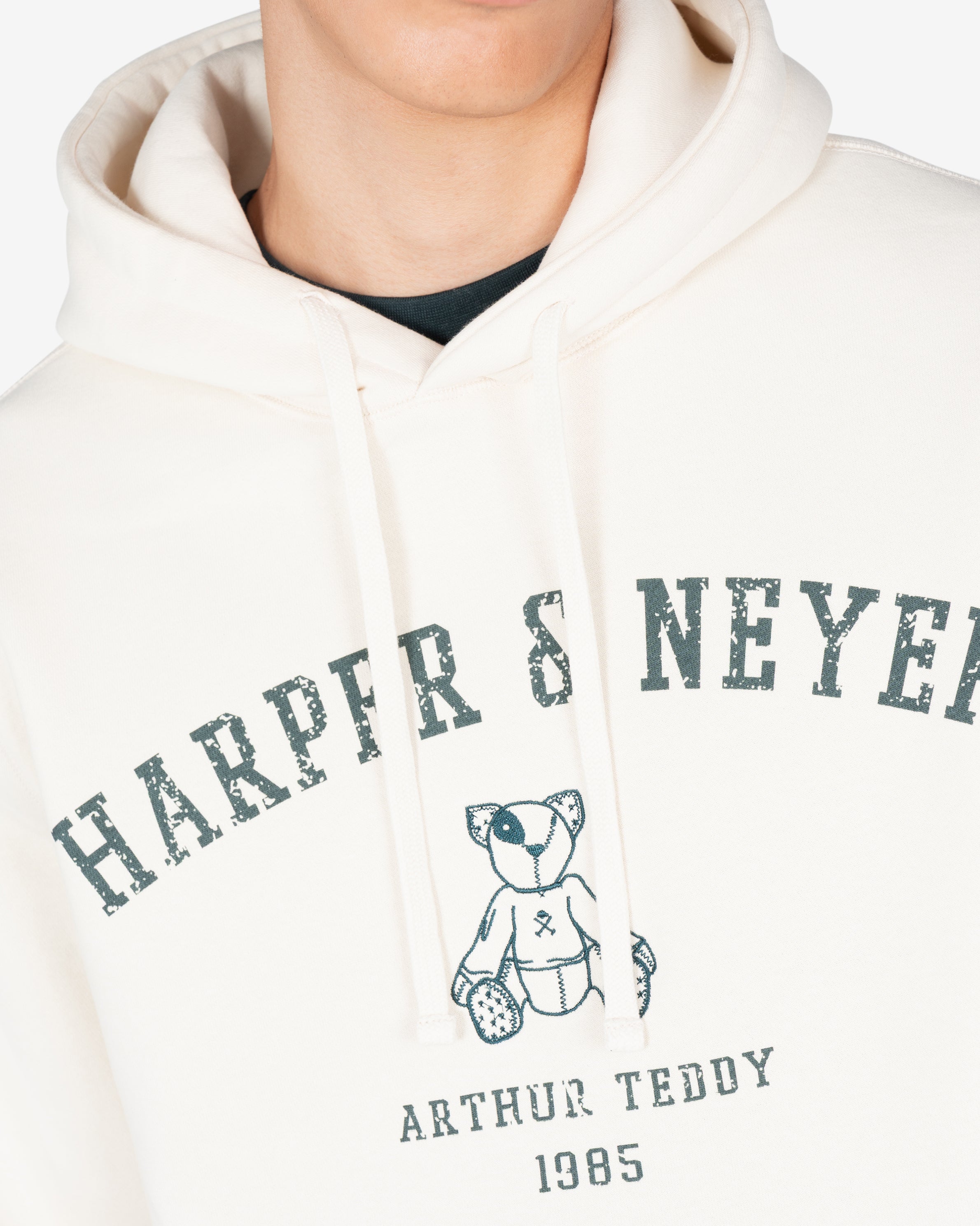 Detalle del estampado Harper Neyer en verde botella y osito Arthur Teddy bordado en la sudadera MANCHESTER crudo
