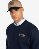 Sudadera MICHIGAN de Harper & Neyer en azul marino, plano medio con oxford asomando por el cuello y gorra Harper
