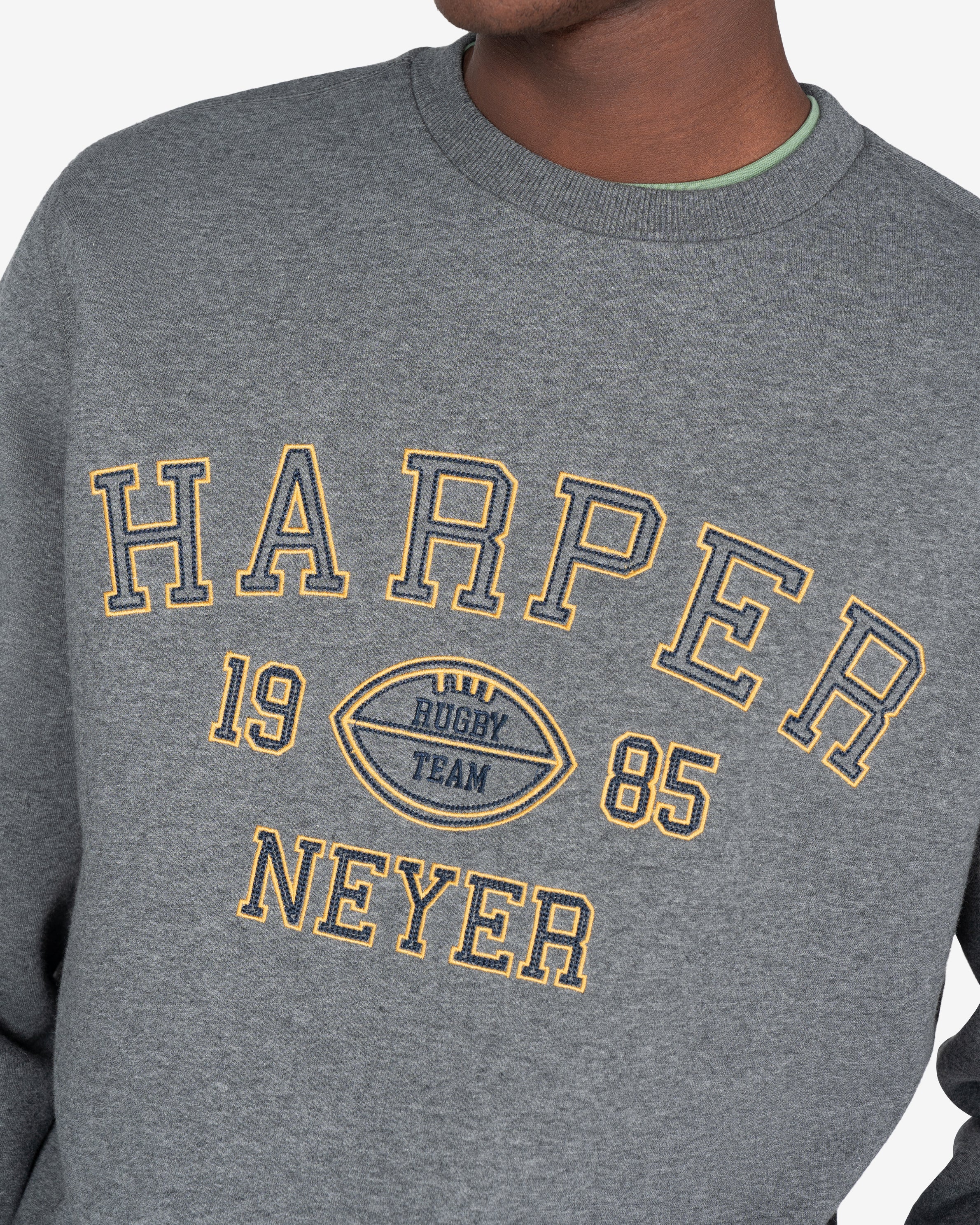 Detalle del estampado applique Harper Neyer 1985 en cadeneta amarilla sobre gris jaspeado de la sudadera RUGBY de Harper & Neyer