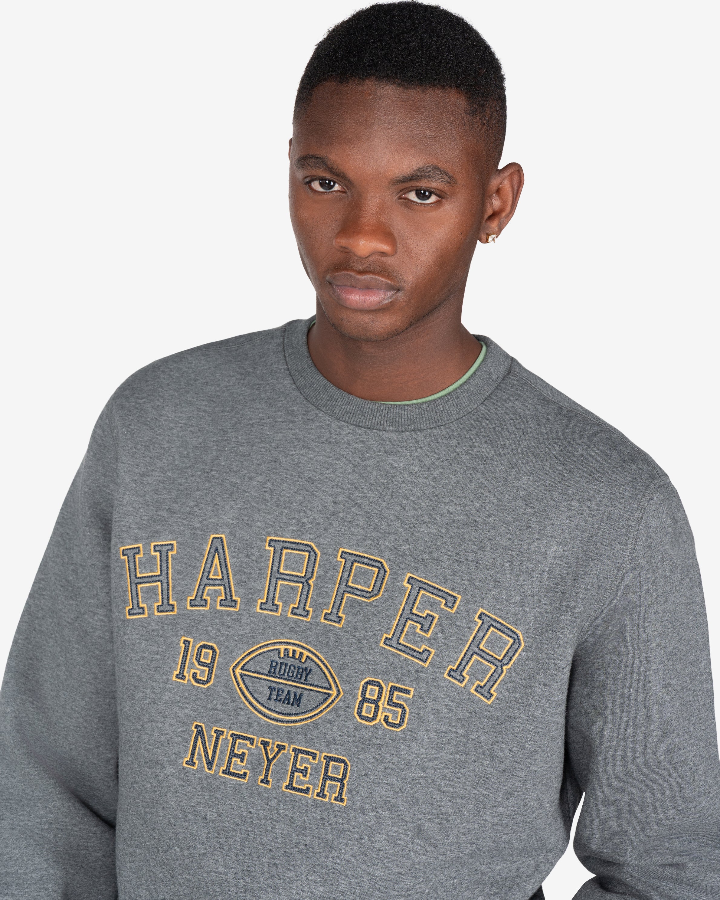 Sudadera RUGBY de Harper & Neyer en gris oscuro jaspeado, plano medio con estampado y camiseta verde salvia asomando por el cuello