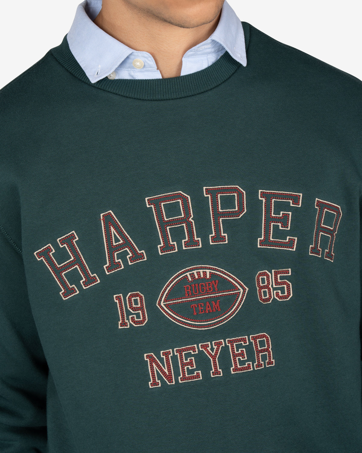 Detalle del estampado applique Harper Neyer 1985 en cadeneta rojo y crema de la sudadera RUGBY verde botella de Harper & Neyer