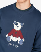 Detalle del oso Teddy en appliqué con blanket stitch y jersey burdeos con logo Harper & Neyer de la sudadera azul marino